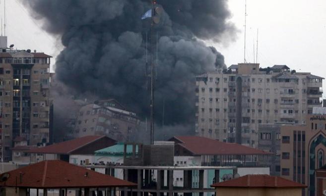 Un edificio en el centro de Gaza se derrumba tras ser alcanzado por...