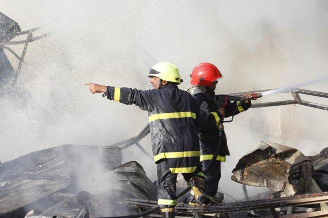 Dos bomberos intentan sofocar el fuego tras los ataques suicidas de...