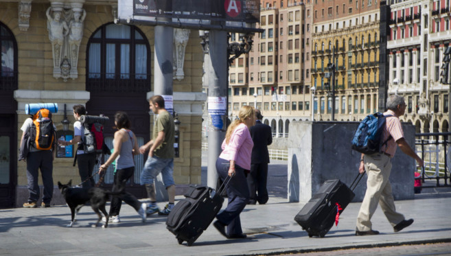 Turistas con maletas y mochileros en Bilbao.