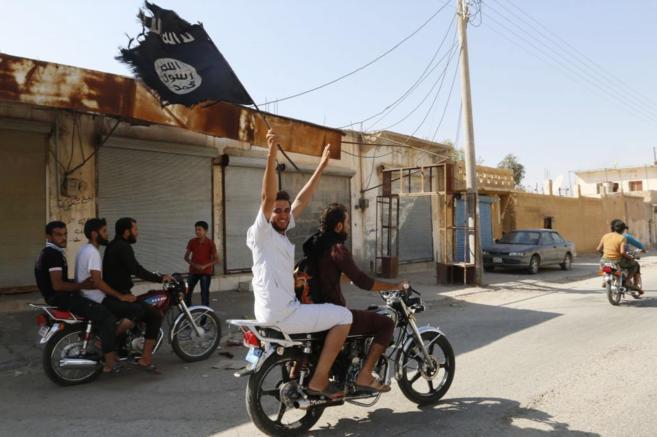 Unos residentes celebran la toma de la base area de Taqba por el IS...