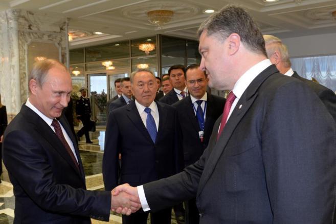 Putin (izda.) y Poroshenko se dan la mano en Minsk.