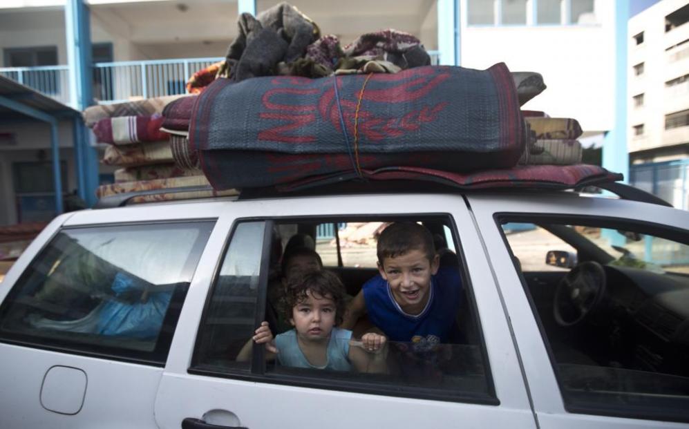 Una familia palestina se dispone a abandonar un colegio de las...