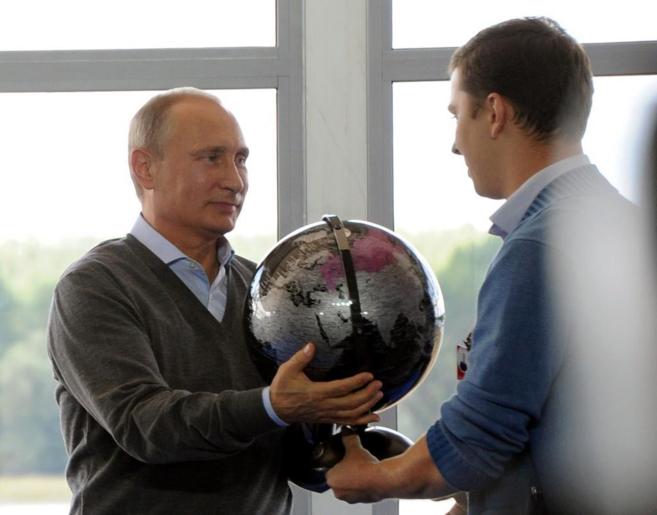 Putin recibe un globlo del mundo de manos de un estudiante, hoy en...