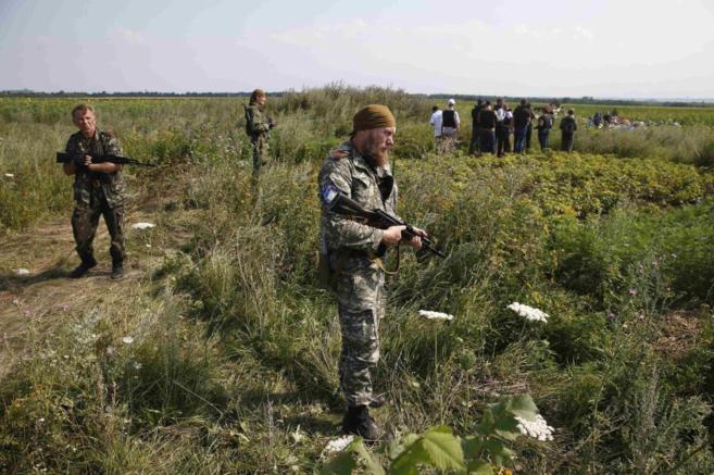 Varios separatistas vigilan a un grupo de observadores de la OSCE que...