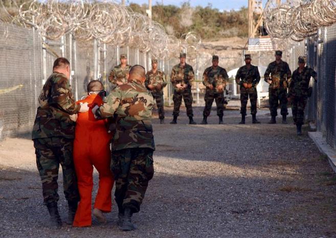 Dos policas militares trasladan a su celda a un detenido en...