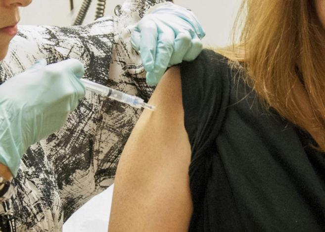 Una paciente de 39 años recibiendo una inyección con la vacuna...