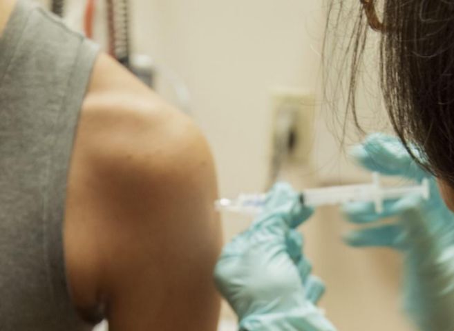Un paciente de 27 aos recibiendo una inyeccin con la vacuna...