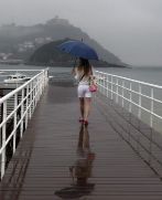 Una joven paseando bajo la lluvia en el Club Nutico de San...