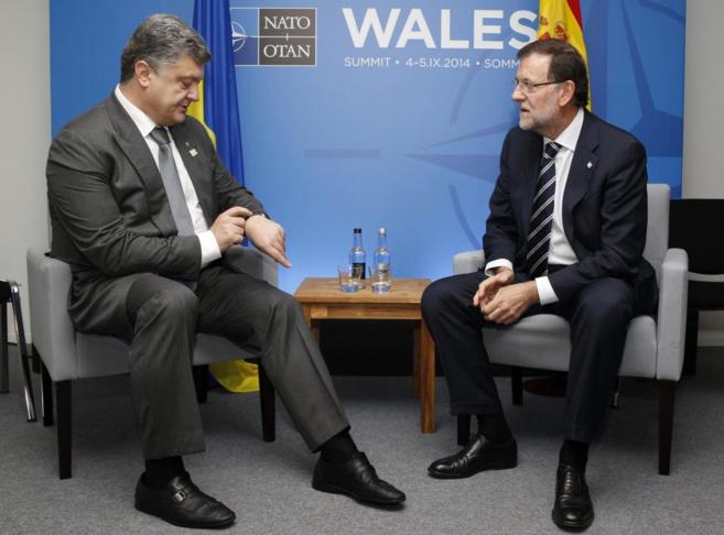 El presidente español, Mariano Rajoy (dcha.), conversa con el de...