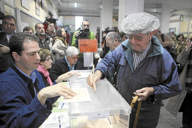 Un ciudadano deposita su voto en una urna de un colegio electoral de...