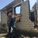 Vladimir, de 50 aos, posa junto a su casa destruida en Ilovaisk...