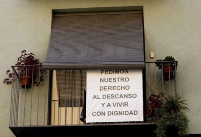 Un vecino del barrio de El Carmen protesta con una pancarta en su...