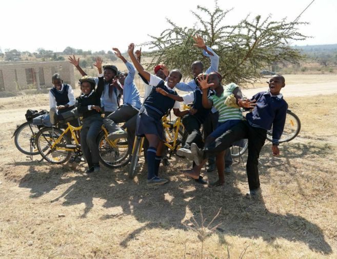 Un grupo de jvenes celebran la entrega de bicicletas en su poblado.