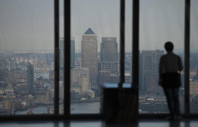 Una mujer observa la ciudad de Londres desde lo alto del Edificio...