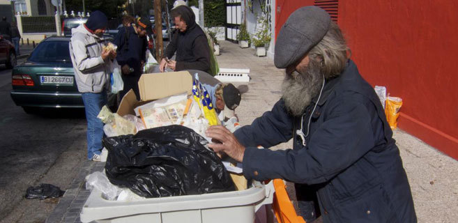 Varias personas buscan comida en contenedores de Madrid