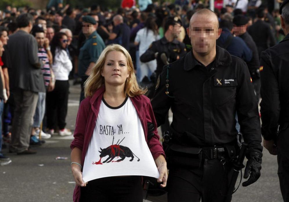 Una joven manifestante muestra una camiseta con el lema 'Basta ya'.