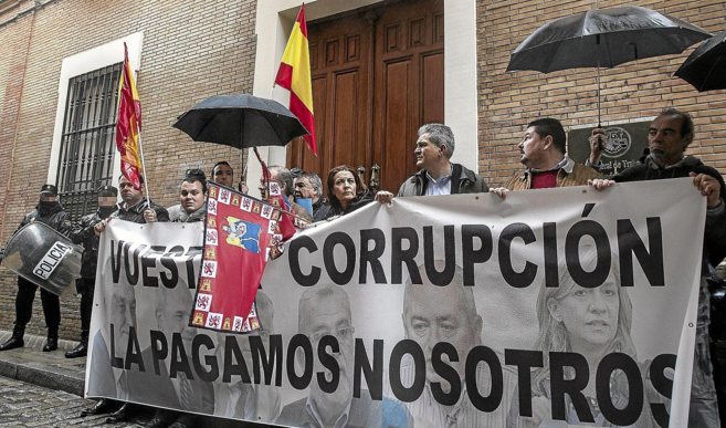 Manifestantes exhiben una pancarta contra la corrupcin ante la sede...
