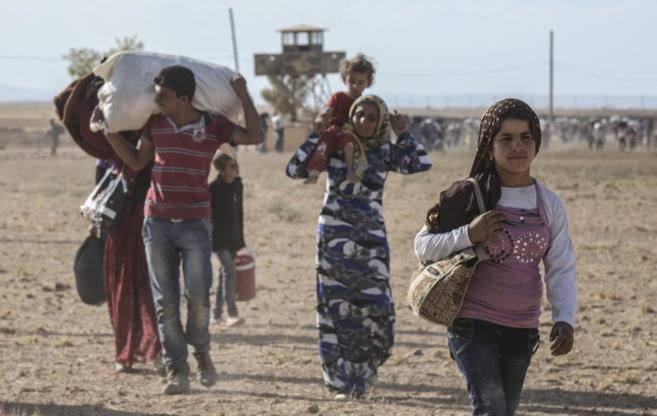 Un grupo de kurdos cruza la frontera entre Siria y Turqua para huir...