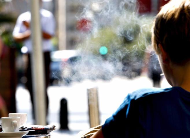 Un hombre fuma en la terraza de un local.