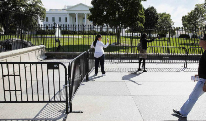 Varios visitantes se hacen un 'selfie' a la Casa Blanca al...