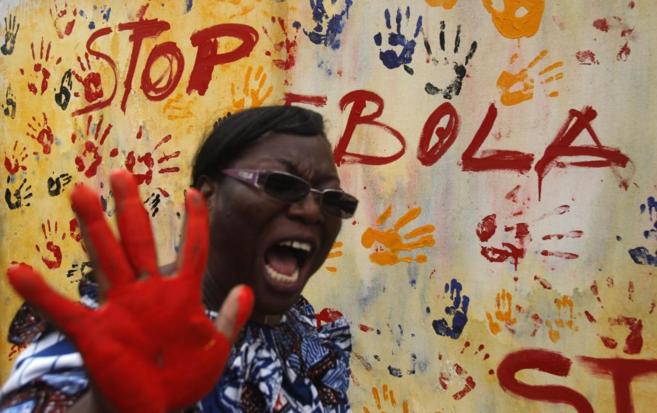 Una mujer posa junto a un mural contra el bola en Abiyn (Costa de...