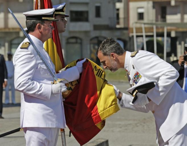 El Rey besa la bandera durante el acto celebrado en la escuela naval.