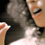 Una mujer tomando una pldora anticonceptiva.