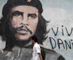 Un estudiante pasa junto a un mural del Che Guevara en Managua...