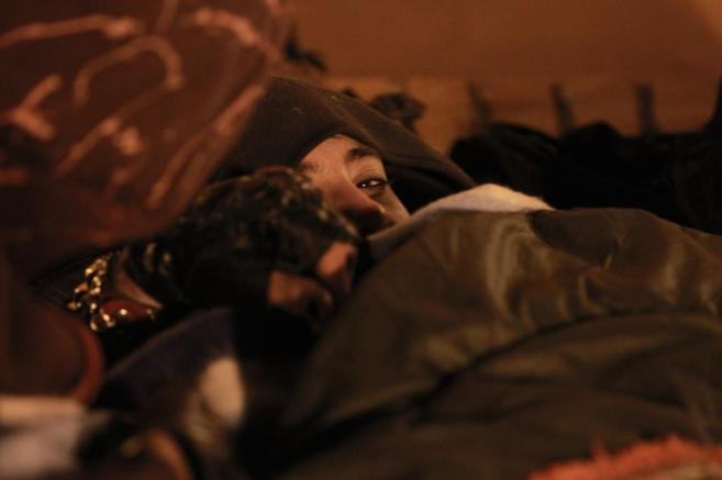 Un mendigo duerme al raso en Madrid.