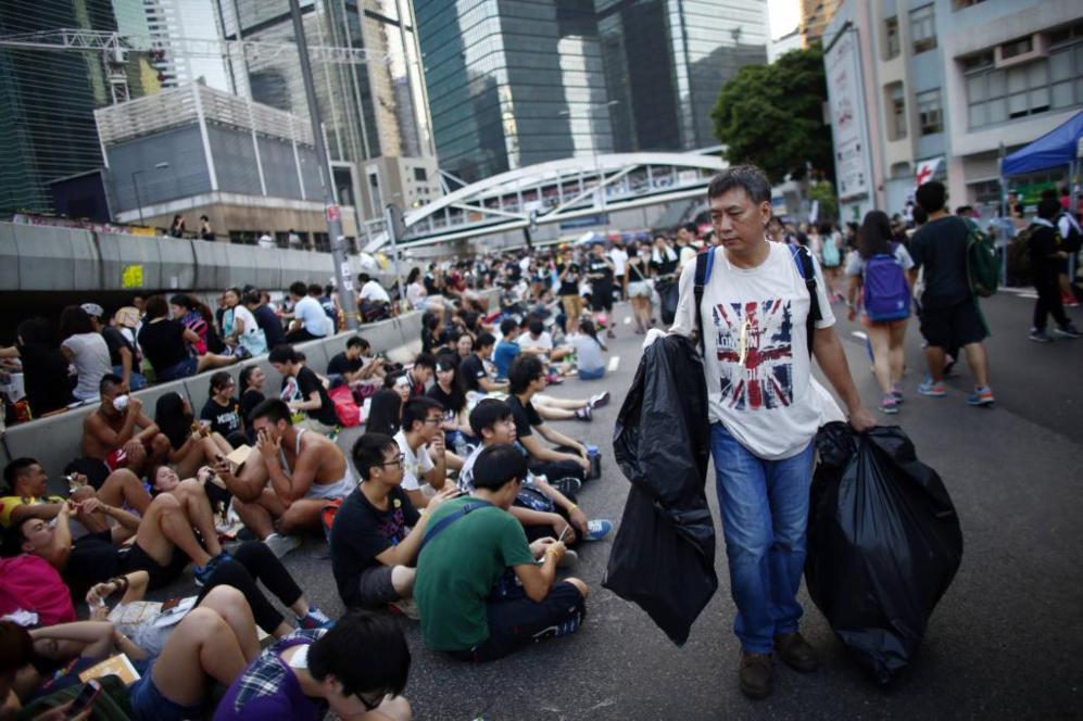 Un hombre recoge basura en el lugar ocupado por los manifestantes en...