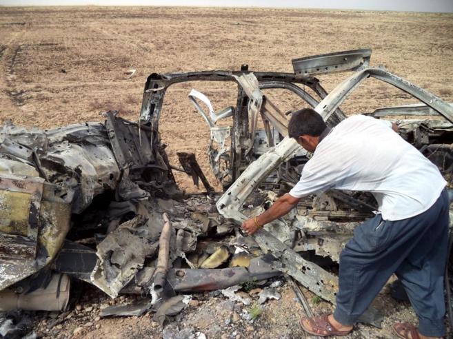 Un iraqu inspecciona un camin destruido usado por integrantes de...