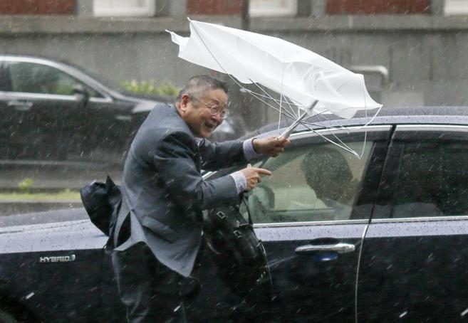 Un hombre trata de luchar contra los vientos huracanados de Tokio.