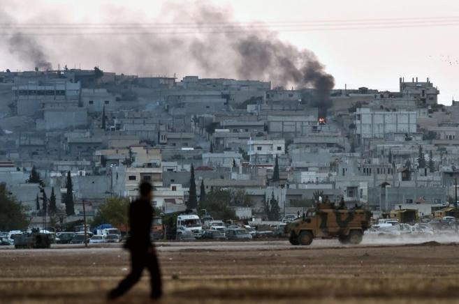 Una columna de humo se levanta desde el centro de la ciudad siria de...