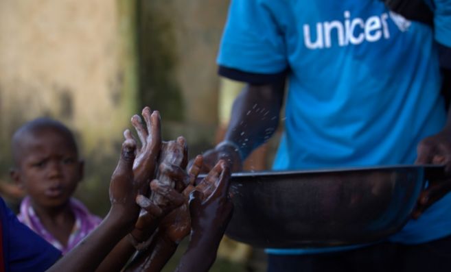 Un miembro de Unicef muestra a los nios cmo lavarse las manos para...