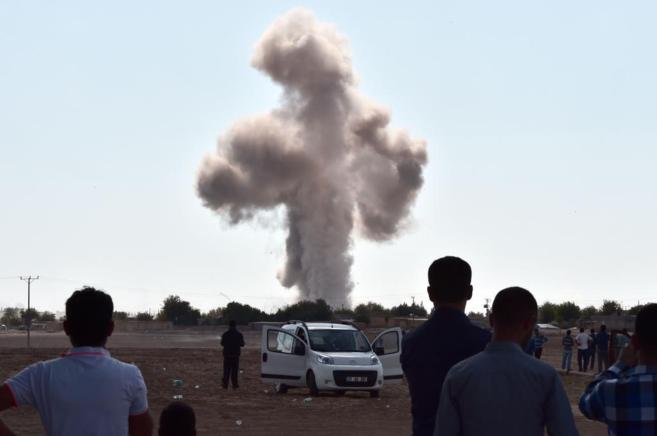 Una columna de humo se alza sobre Kobane tras los bombardeos de la...