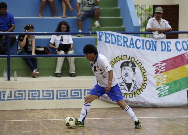 Evo Morales participa en un partido de fútbol junto a una pancarta de...