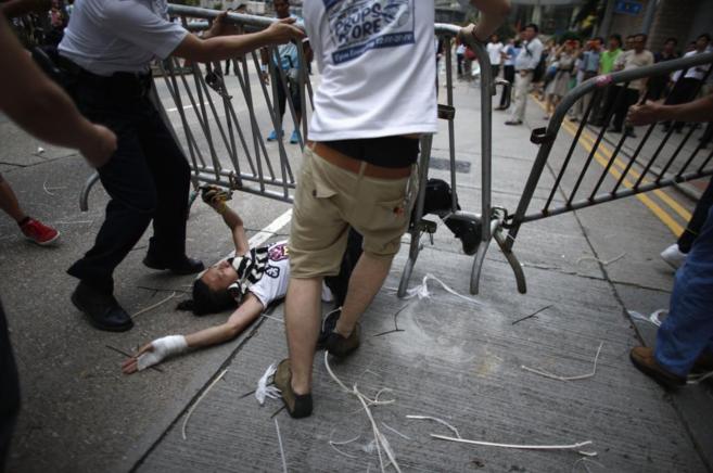 Los anti manifestantes pro democracia intentan retirar una valla del...