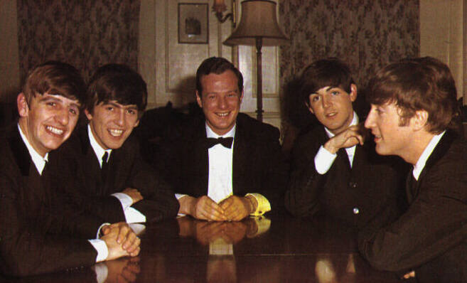 Brian Epstein, en el centro, rodeado por los Beatles.