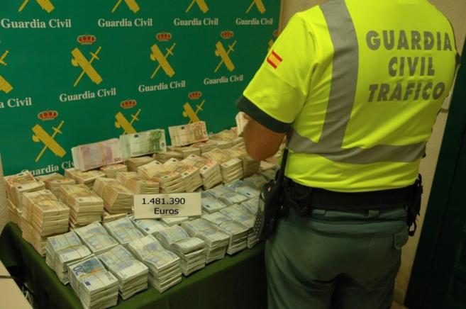 Un agente de la Guardia Civil cuenta el dinero intervenido.