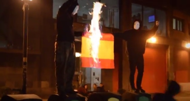 Los encapuchados queman una bandera española en Barakaldo.
