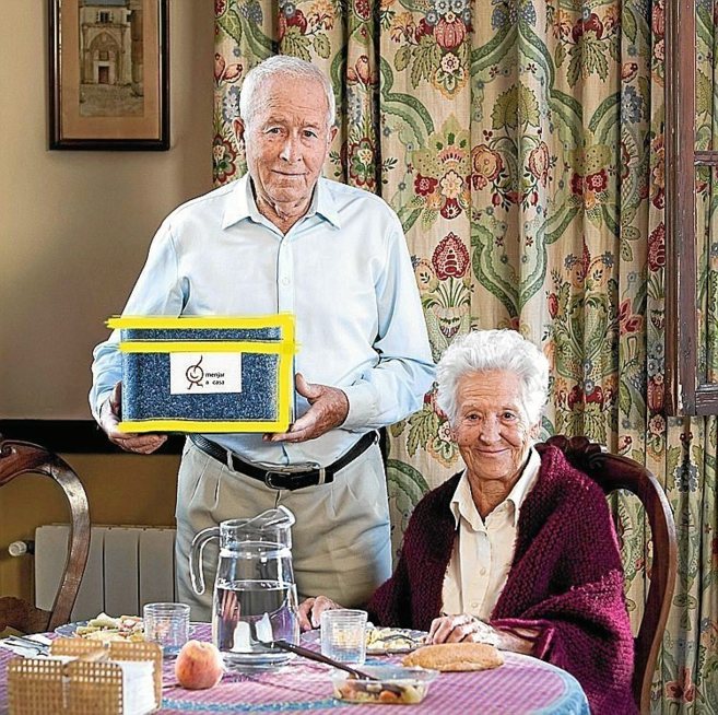 Dos personas mayores con un servicio de 'Menjar a Casa'.