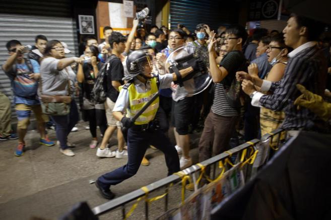 Un polica golpea con su porra a decenas de estudiantes en Hong Kong.
