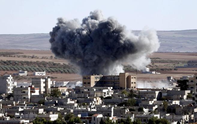 Una columna de humo se eleva, ayer, en Kobane, tras un ataque contra...
