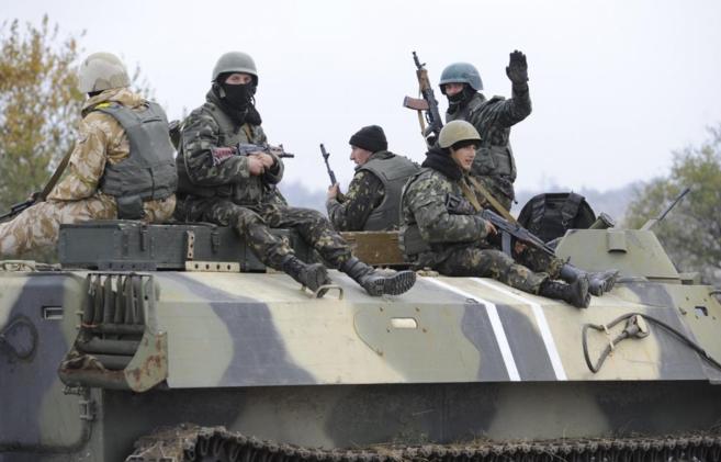 Soldados ucranianos sentados sobre un vehculo militar cerca de la...