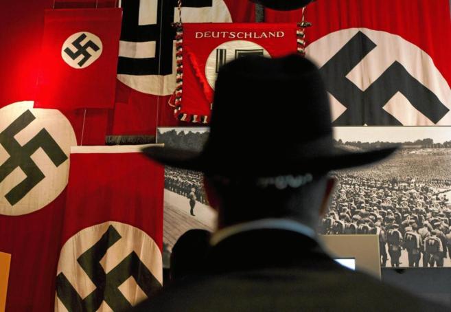 Un hombre observa las banderas nazis durante una visita al Museo Yad...