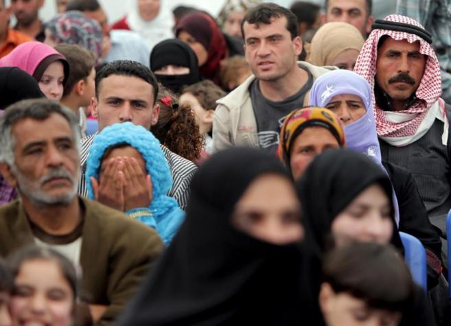 Refugiados sirios esperan su turno para registrarse en uno de los...