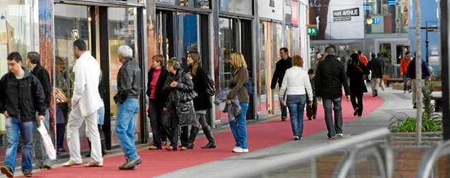 Consumidores hacen sus compras en los comercios del centro comercial.