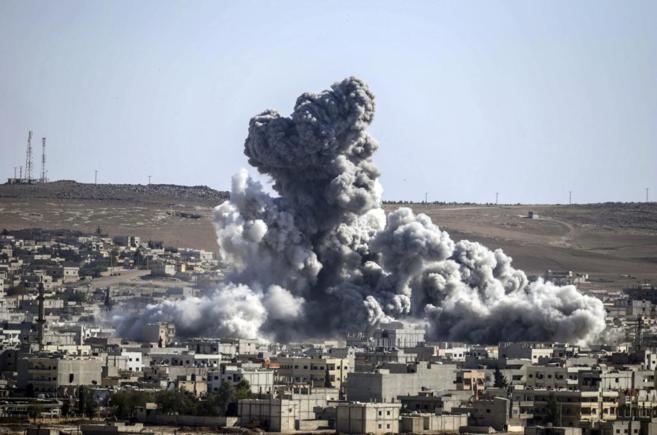 Una columna de humo emerge de la ciudad siria de Kobane tras una...