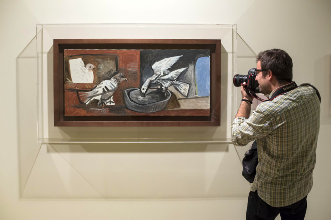 Un fotgrafo ante el cuadro de Picasso 'Tres palomas'....