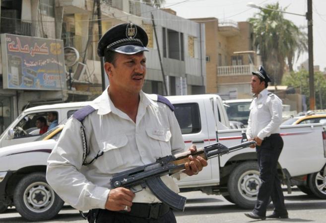 Dos policas iraques hacen guardia, en Bagdad.
